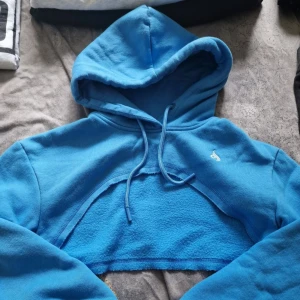 Blå croppad hoodie - Säljer en superfin blå croppad hoodie från Ryderwear. Den är i fleece och har en mysig luva med dragsko. Perfekt för en chill dag eller när du vill ha något bekvämt men ändå snyggt. Passar perfekt till jeans eller leggings! 💙