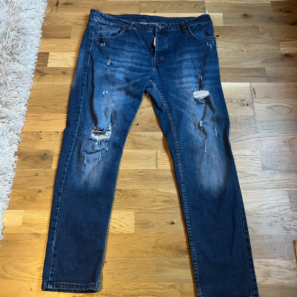 Säljer ett par snygga blå jeans från Dsquared2 i storlek 54. De har en cool slitning och är i slim fit. Perfekta för en avslappnad stil med lite edge. Byten är intressant priset är inte hugget i Sten, inga kvitton eller liknade finns därav priset . Jeans & Byxor.