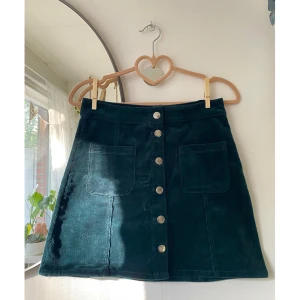 Mörkgrön Manchester kjol - Säljer denna superfina Manchester-kjol från H&M divided. Den är mörkgrön och kort. Stl 32. Passar bra för både sommar och höst. Skriv om du har frågor :)✨