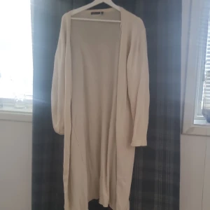 Beige lång kofta från Brave Soul - Säljer en superfin beige lång kofta från Brave Soul. Den är perfekt för höst och vinter, och är gjord av ett mjukt stickat material. Koftan har långa ärmar och en öppen design utan knappar eller dragkedja. Perfekt att slänga på sig över en t-shirt eller blus för en mysig och stilren look. 🧥✨