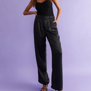 Kostymbyxor  - Kostymbyxor i satin från Gina Tricot. Aldrig använts, storlek 42. Nypris var 499kr.