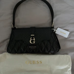 Väska GUESS - En helt nyköpt Guess väska ÄKTA. Köptes för 1125kr och säljer för 780kr ENDAST DENNA VECKA.