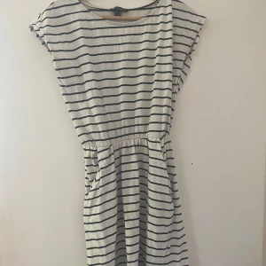 En klänning  - En vit randig klänning. Som på bilden. Gjord av 50% modal och 50% bomull 