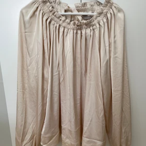 Beige blus  - Beige blus från H&M med fina detaljer. Rosett i nacken som man kan knyta själv. Använd fåtal gånger. Storlek L