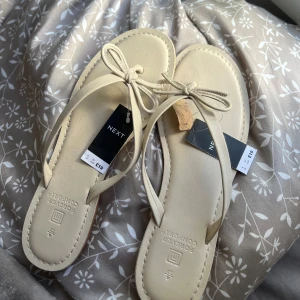Söta flipflops  - Säljer dessa söta oanvända flipflops. Dom är i en creme vit / beigh färg med en gullig roset på😝 storlek 37 Köpta för 345kr