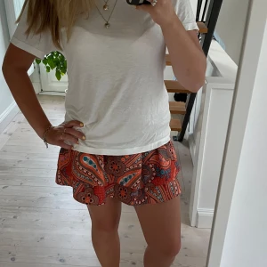 Kjol - Säljer en superfin och färgglad kortkjol. Kjolen har en volangdetalj och är i toppenskick. Den är väldigt stretchig i midjan så väldigt bekväm att ha på sig💕skriv om ni har några frågor💕💕