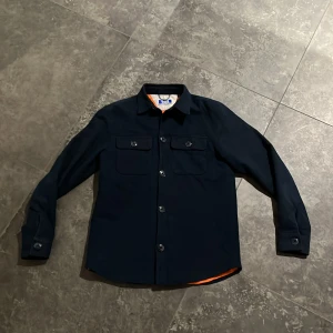 Mörkblå Overshirt - Säljer denna Mörkblå Overshirt ifrån Jack&Jones. Den är i väldigt bra skick och säljs för ett bra pris. Storlek: 164Cm. Hör av er vid funderingar så löser vi en bra deal. (Nypris 799kr) 