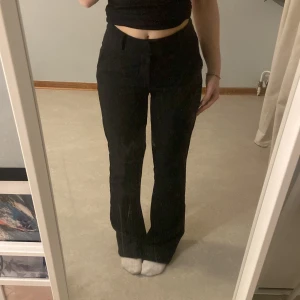 Svarta kostymbyxor med bootcut - Snygga svarta kostymbyxor med bootcut-stil och hög midja. Perfekta för en stilren look. De har en klassisk design med knappar och dragkedja framtill❤️Storlek 34 från Bikbok, säljer då byxorna kommer inte till användning längre, använts väldigt få gånger så i perfekt skick!