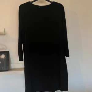 Svart klänning  - Snygg svart klänning från Gina Tricot i enkel och stilren design. Klänningen har trekvartslånga ärmar. 