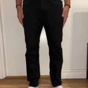 Svarta jeansbyxor - Snygga svarta jeans med en klassisk design. De har en normal passform och raka ben. Perfekta för en stilren look. Har knappt kommit till användning. Storlek W32 L32, köpt för 1 000kr säljer för 499kr