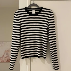 Svartvit randig tröja från C.W. - Säljer en stilren svartvit randig tröja från Carin Wester. Tröjan är ribbad och har långa ärmar, perfekt för en avslappnad look. Den är gjord i ett mjukt material som känns skönt mot huden. Passar bra till både jeans och kjol.