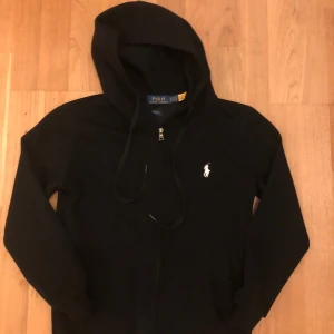 Ralph lauren zip - Svart Polo Ralph Lauren hoodie i storlek S passar även Xs. Klassisk design med dragkedja, fickor och broderad logga på bröstet. Mjukt material, perfekt för vardagsbruk. Fint skick.