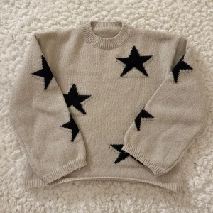 Beige stickad tröja med stjärnor - Säljer en mysig beige stickad tröja med svarta stjärnor. Lappen står inte kvar så vet inte vart den är ifrån .Använt ett antal gånger men nu passar den tyvärr inte längre!