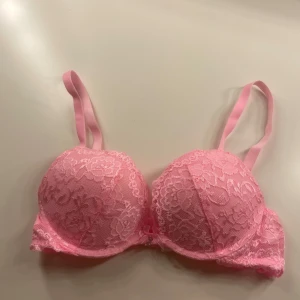 Rosa spets-bh - Säljer en söt rosa push up- bh med spetsdetaljer i storlek 70B. Den har justerbara axelband och en mjuk kupa för extra komfort. Köpt fårn Cubus, nypris 249. Aldrig kommit till användning så den är som ny 🩷