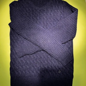  J.Lindeberg - Säljer en stilren mörkblå stickad tröja från J.Lindeberg med kabelstickat mönster på framsidan ut av tröjan. Tröjan har inga håll fläckar eller anat. Perfekt för att se bra och hålla sig varm på kyligare dagar.priset går att diskutera 