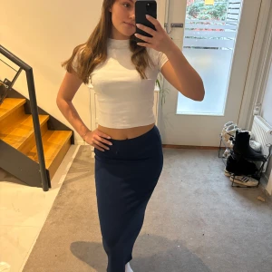 Mörkblå långkjol - Säljer en stilren mörkblå långkjol med en tight passform. Kjolen är enkel och elegant, perfekt för olika tillfällen. Den har en hög midja och är gjord i ett mjukt och bekvämt material.🩵💙🤍