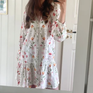 Blommig vit klänning - Såååå fin blommig klänning perfekt till sommaren!!!🩷🩷🩷🩷🩷💐🌷🌹🌸🌺använd en gång❤️