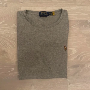 Grå t-shirt från Ralph Lauren - Säljer en klassisk grå t-shirt från Ralph Lauren med det ikoniska broderade logotypen på bröstet. Nästan aldrig använd och är som ny i skicket. Inga fläckar eller hål. Och är i storlek S och måtten finns med på bilderna.  Skickar inom 24tim 💨 och priset kan diskuteras.