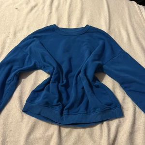 Blå tröja från 157 - Säljer en blå tröja från 157 i storlek XS/S. Tröjan har långa ärmar och en rund halsringning med ribbade muddar vid ärmslut och nederkant. Perfekt för en avslappnad stil.