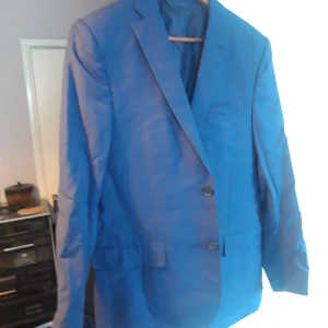 Blå kavaj från J.Lindeberg - Snygg blå kavaj från J.Lindeberg i slim fit. Perfekt för en stilren look. Tillverkad i Italien av Angelico.
