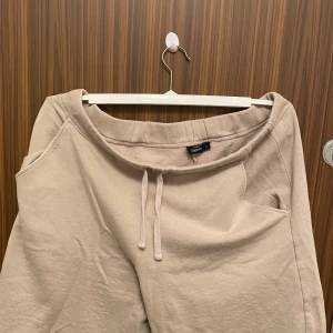 Beige shorts från KappAhl - Säljer ett par bekväma beige shorts från KappAhl. De har en avslappnad passform med dragsko i midjan för justerbarhet. Perfekta för en avslappnad dag.
