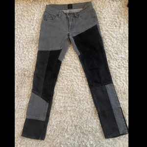 Grå och svarta patchwork jeans från Tiger of Sweden - Unika patchwork jeans i grått och svart från Tiger of Sweden. Byxorna har en straight passform och är tillverkade i jeansmaterial. Perfekta för dig som vill ha en stilren men ändå iögonfallande look.