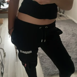 Svarta mjukisbyxor från Hoodrich - Snygga svarta mjukisbyxor från Hoodrich med elastisk midja och snörning. Byxorna har en avslappnad passform och praktiska fickor på sidorna. Perfekta för en chill dag hemma eller en snabb tur på stan. 🩷