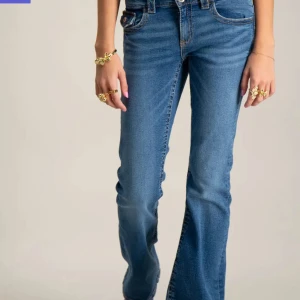 Blå bootcut jeans - Snygga blå bootcut jeans med knappar på fickorna. Perfekta för en avslappnad stil med en touch av retro. Passar bra till både sneakers och klackar. Så sjukt fina och hör gärna av dig om du har frågor❤️storlek 170/xs-s