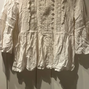 Jätte fin vit blus från River Island, sommar blus!!! - Den är i ganska bra skick, inga fläckar eller hål bara lite skrynklig men det går och fixa med att stryka den. Ganska tunt tyg så man kan se igenom lite. De fina mönstren som finns på bröstet, kan man inte se igenom mycket efter som det finns ett litet tunt tyg bakom den. Armarna kommer ungefär vid armbågarna kanske också lite längre beror på armlängd. 