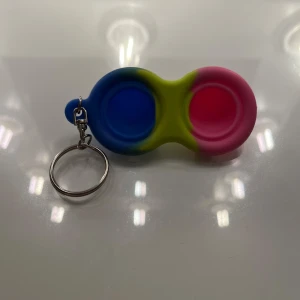 Multifärgad fidgettoy-nyckelring - Den är som ny och perfekt att ha på till exempel nycklarna ligger om man vill greja med någonting smått! Köpt för 70kr!