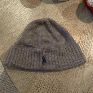  Mössa från Polo Ralph Lauren - Snygg grå mössa från Polo Ralph Lauren i merinoull.