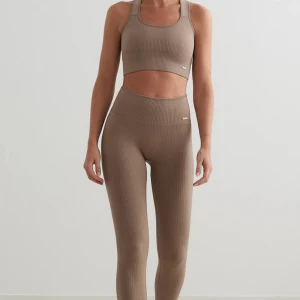 Ribbat Aimn set - Snygga bruna ribbade leggings med matchande topp. Setet har en tight passform och är perfekt för träning eller en avslappnad dag. Högmidjade leggings som ger en smickrande siluett. Färgen är dom de första bilderna, min kamera ville inte ta upp färgen. Har inte använt setet. Färg: Espresso, byxor ord: 599kr, topp ord: 399kr 🤎priset är för hela setet