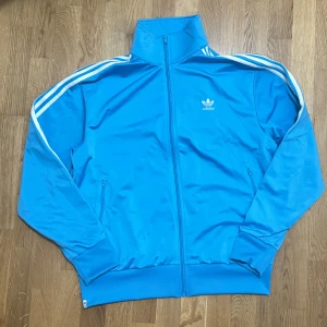 Adidas träningsjacka - Adidas ljusblå trackjacket. Använt typ 2 gånger. Vill sälja eftersom den är för stor för mig. 