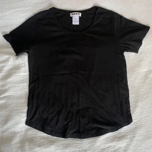 Svart t-shirt från Hope - Snygg svart t-shirt från Hope i en klassisk design. Perfekt för en stilren look. Tillverkad i Portugal.