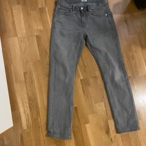 Grå jeansbyxor från 157 - Helt nya, Snygga grå jeansbyxor från 157 med en klassisk femficksdesign. De har en dragkedja och knapp framtill. Perfekta för en stilren look.