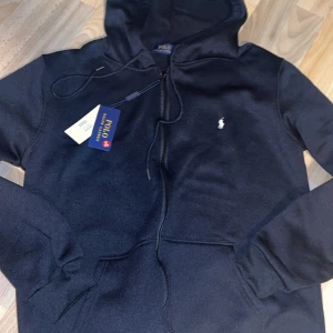 Polo Raulph Lauren zip tröja - Zip trörja från Polo Raulph Lauren. Helt ny aldrig använt i storlek S. Lappar och taggar följer med. Pris 1099kr och kan diskuteras via snabbaffär.