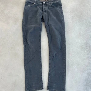Grå jeansbyxor från Jacob Cohen - Snygga grå jeansbyxor från Jacob Cohen i storlek 32, passar dig som är runt 175-185. Skick 8/10. Nypris 5000 mitt pris 1199. Säljs för att dom inte kommer till användning. 