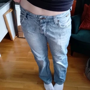 Lågmidjade baggy jeans - Så snygga lågmidjade vintage blå jeans. Så snygga detaljer och baggy rak passform. Älskar bakfickorna! Klassisk femficksdesign. Jeansstorlek 32 (så inte samma som eu 32!). 100 % bomull. Tyvärr är det slitage och hål mellan benen som man kan vilja laga, så säljer väldigt billigt! Förutom det är de i bra skick🩷
