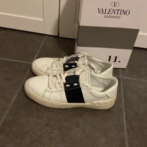 Valentino Garavani sneakers - Snygga Valentino Garavani sneakers i vitt med svarta detaljer. Skorna har en klassisk design med snörning och en stilren look. 