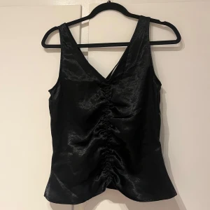 Svart topp - Fin topp med v-ringning och rynkdetaljer framtill, aldrig använd 🖤