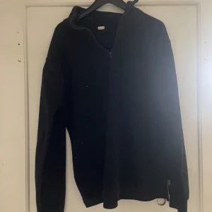 Svart tröja med dragkedja från Walking - Säljer en svart tröja från Walking med dragkedja. Perfekt för kyligare dagar. Tröjan har långa ärmar och en enkel design som passar till det mesta. Ett bra val för en stilren look.