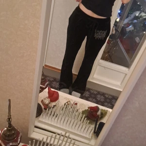 Svarta mjukisbyxor med broderi - Säljer ett par svarta mjukisbyxor med snyggt broderi på sidan. Byxorna har en bekväm passform och dragsko i midjan för justerbarhet. Perfekta för en avslappnad stil.