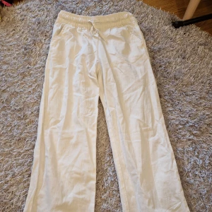 Vita linnebyxor med resårmidja - Säljer ett par bekväma och stilrena vita linnebyxor från 157. De har en elastisk midja med snörning. Perfekta för en avslappnad sommarlook! Bra skick.