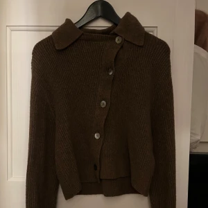 Kofta m knäppning - Jättefin brun stickad kofta med sneknäppning framtill. Bra skick, knappt använd 