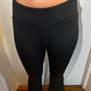 Svarta leggings - Säljer ett par svarta leggings som är superbekväma och perfekta för både träning och vardag. De är högmidjade och har en tight passform som framhäver figuren de är äcen utsvängda nedtill. Materialet är mjukt och stretchigt, vilket gör dem sköna att ha på sig hela dagen.