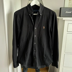 Svart Ralph Lauren Skjorta - Svart Polo Ralph Lauren skjorta i som nytt skick! Sitter som S slim fit. Nypris ca 1700kr.