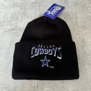 NFL svart mössa - Svart mössa med Dallas Cowboys-logotypen. Mössan är ny och oanvänd, med alla originaletiketter.