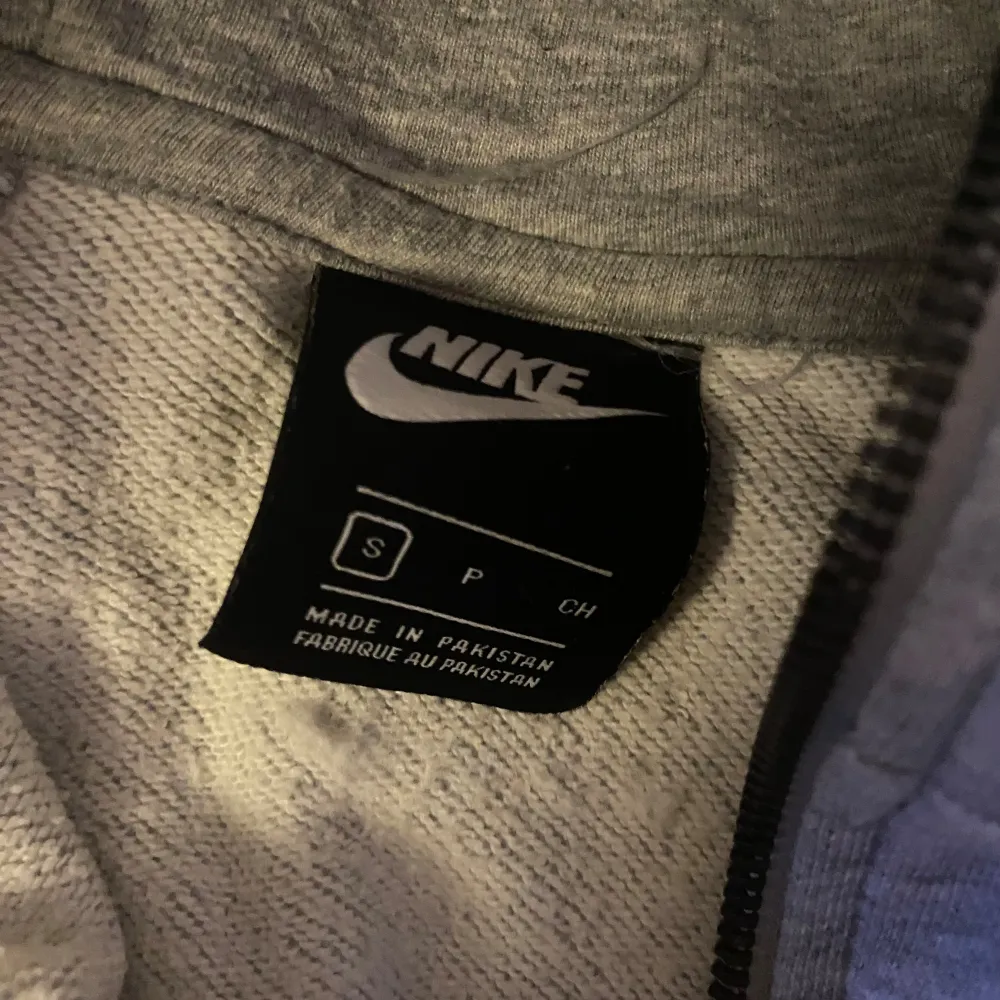 Säljer en klassisk grå hoodie från Nike i storlek S. Den har en dragkedja framtill och en justerbar huva med snören. Perfekt för en avslappnad stil eller träning. Superbekväm och lätt att matcha med allt!. Tröjor & Koftor.