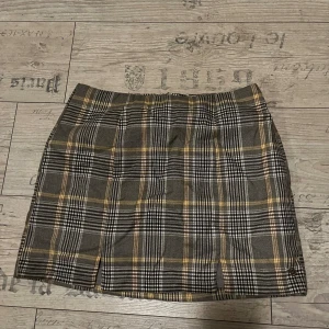 Rutig kjol från Pull & Bear - Rutig minikjol från Pull & Bear, storlek M/38, med slits framtill. Har dragkedja back. Använd 1/2 gånger