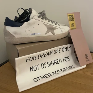 Golden Goose  - Ett par Vita golden goose med blå häl, knappt använda och har varit inne på tvätt så dom ser helt nya ut. Skorna är i storlek 45/44. Allt og är kvar i bra skicka. Bra pris för snabb affär!